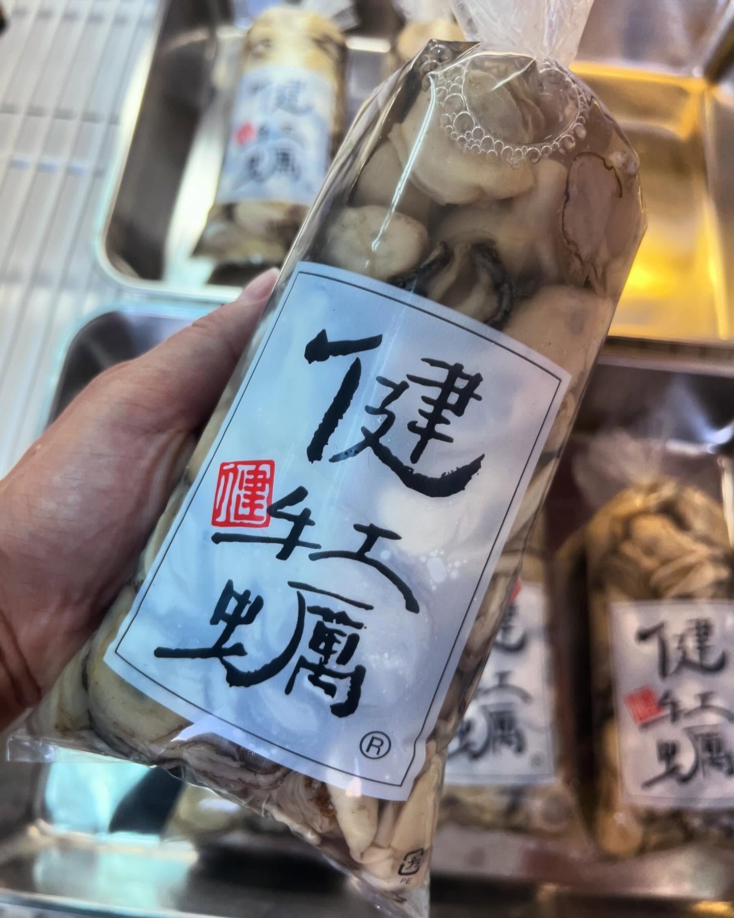 パッケージされた健牡蠣の生牡蠣を手に持っている様子