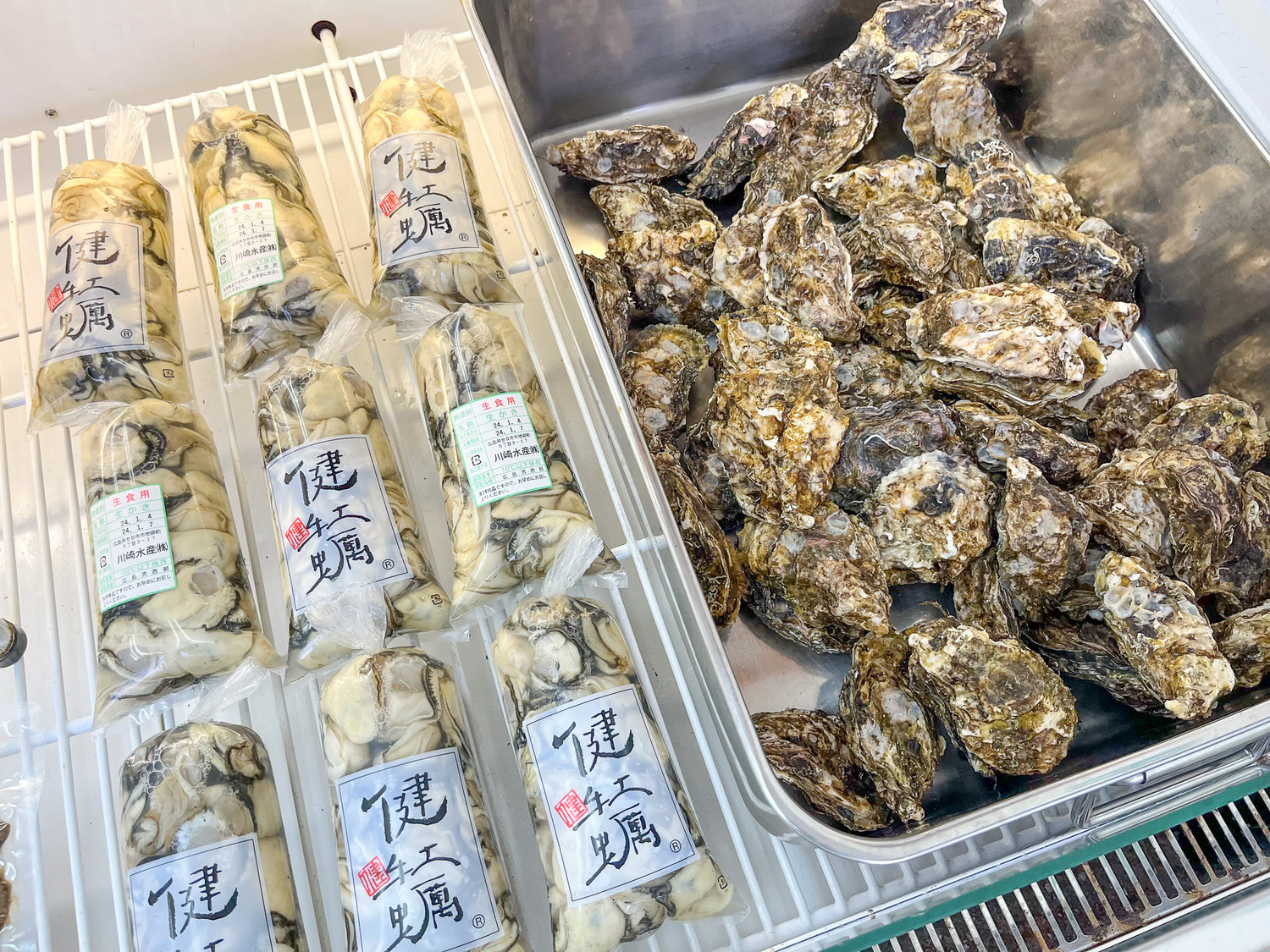 パッケージされたむき身の生牡蠣と殻付きの牡蠣が並んでいる